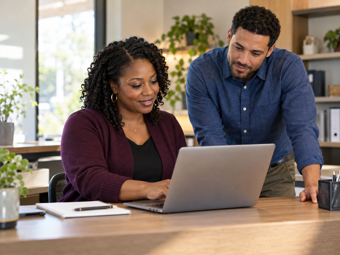 Illustration of training coordinators working together at a laptop